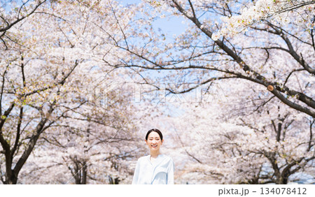 桜並木を見上げる若い女性　ライフスタイルイメージ 134078412