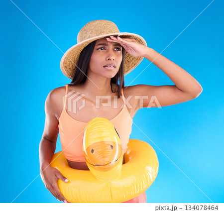 Studio, shocked woman on beach and vacation on blue background, looking or search with hat and hand on face. Travel, pool holiday and worried girl with inflatable rubber duck, ocean wear on holiday. Studio, shocked woman on beach and vacation on blue background, looking or search with hat and hand on face. Travel, pool holiday and worried girl with inflatable rubber duck, ocean wear on holiday. 134078464