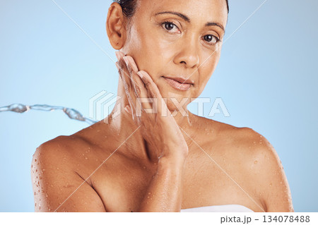 Water splash, skincare and portrait of mature woman with health, wellness and cleaning isolated on blue studio background. Shower, mockup and cosmetic beauty, model in anti ageing skin care treatment Water splash, skincare and portrait of mature woman with health, wellness and cleaning isolated on blue studio background. Shower, mockup and cosmetic beauty, model in anti ageing skin care treatment 134078488