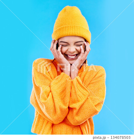 Happiness, excited and woman with youth in studio ready for cold weather with winter hat. Isolated, blue background and smiling with a happy young and gen z person with a smile, beanie and joy Happiness, excited and woman with youth in studio ready for cold weather with winter hat. Isolated, blue background and smiling with a happy young and gen z person with a smile, beanie and joy 134078503