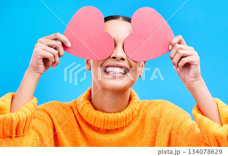 Heart eyes, cover and woman with happiness and excited about love, valentines day or emoji. Happy, smile and person with isolated blue background, loving or creative romance paper symbol to show care 134078629