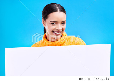 Happy, mockup and poster with portrait of woman in studio for idea, branding and announcement. Promotion, space and smile with female and sign on blue background for news, logo and advertising 134079131