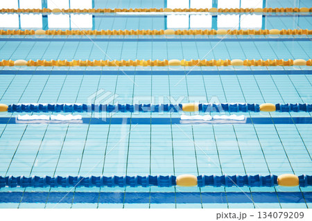 Empty, swimming pool or lines in water for competition or racing lanes for fitness or underwater sports. Background, blue or training arena ready for race performance, workout or exercise challenge Empty, swimming pool or lines in water for competition or racing lanes for fitness or underwater sports. Background, blue or training arena ready for race performance, workout or exercise challenge 134079209