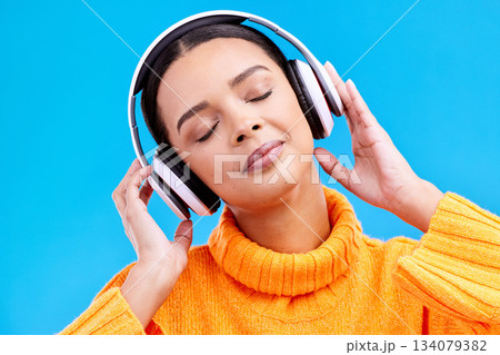 Headphones, calm music and woman in studio, blue background and backdrop. Peace, female model and listening to music, relax and streaming album on audio connection, sound or hearing zen radio podcast Headphones, calm music and woman in studio, blue background and backdrop. Peace, female model and listening to music, relax and streaming album on audio connection, sound or hearing zen radio podcast 134079382