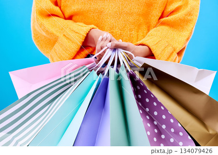 Shopping bags, studio and woman hands with deal and gifts from boutique sale. Retail, customer and female model with store bag and sales choice in isolated blue background with fashion purchase Shopping bags, studio and woman hands with deal and gifts from boutique sale. Retail, customer and female model with store bag and sales choice in isolated blue background with fashion purchase 134079426