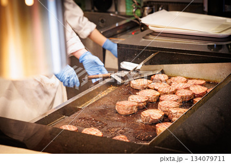 お肉を調理するプロの料理人の調理風景の素材風景 134079711