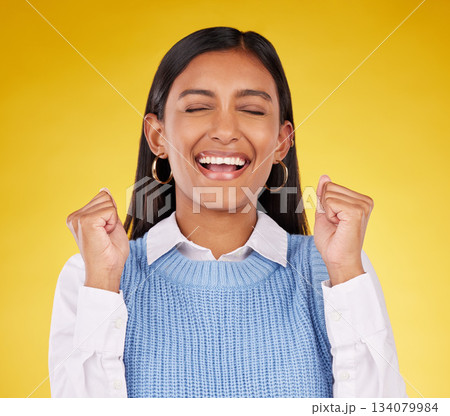 Celebration, winner and fist pump with woman in studio for success, excited and happy cheering. Wow, yes and achievement with female on yellow background for victory, promotion and good news Celebration, winner and fist pump with woman in studio for success, excited and happy cheering. Wow, yes and achievement with female on yellow background for victory, promotion and good news 134079984
