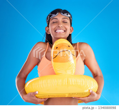 Smile, goggles and rubber duck with a woman on a blue background in studio ready for summer swimming. Happy, travel and vacation with an attractive young female feeling excited to relax or swim Smile, goggles and rubber duck with a woman on a blue background in studio ready for summer swimming. Happy, travel and vacation with an attractive young female feeling excited to relax or swim 134080098
