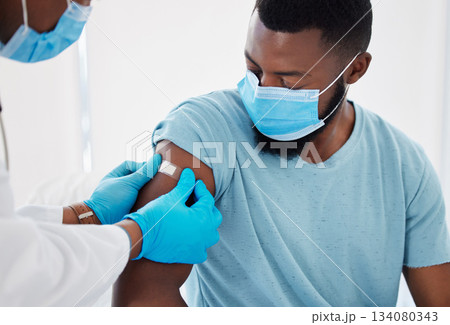 Bandage, covid vaccine with doctor and patient in hospital, safety from virus with plaster and healthcare. People in medical consultation, immunization and black man in face mask and injection wound 134080343