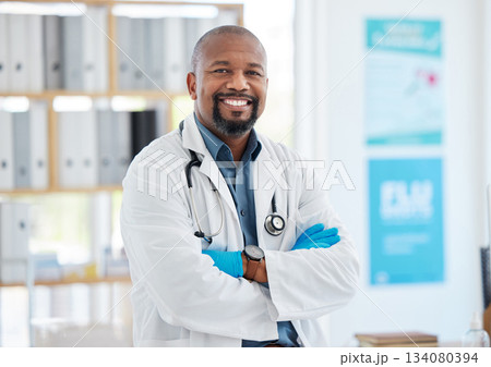 Portrait, doctor smile and black man with arms crossed, pride for career, occupation or job in clinic. Healthcare, mature person and happiness, proud and confident medical professional from Nigeria. Portrait, doctor smile and black man with arms crossed, pride for career, occupation or job in clinic. Healthcare, mature person and happiness, proud and confident medical professional from Nigeria. 134080394