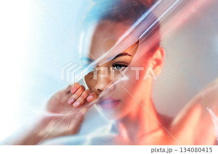 Plastic tear, makeup and face of woman with beauty products, cosmetics and skincare in studio. Creative art deco, aesthetic and eyes of girl with glow, lipstick and luxury style with neon packaging 134080415
