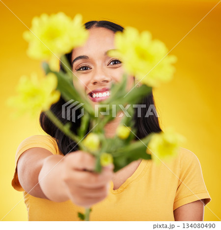 Happy, portrait and woman with flowers as a gift isolated on a yellow background in a studio. Floral, spring and girl giving a bouquet as a present, sharing plants and fresh flower with a smile Happy, portrait and woman with flowers as a gift isolated on a yellow background in a studio. Floral, spring and girl giving a bouquet as a present, sharing plants and fresh flower with a smile 134080490