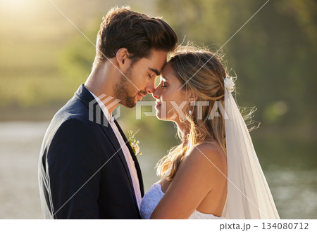 Couple, wedding and forehead by lake on romantic honeymoon or summer getaway together in nature. Married man and woman touching head for marriage, relationship or loving embrace in the outdoors Couple, wedding and forehead by lake on romantic honeymoon or summer getaway together in nature. Married man and woman touching head for marriage, relationship or loving embrace in the outdoors 134080712