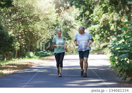 Senior couple, exercise and happy outdoor for a run, workout and training on road for fitness. Elderly man and woman talking about cardio for health and wellness while jogging or running in nature Senior couple, exercise and happy outdoor for a run, workout and training on road for fitness. Elderly man and woman talking about cardio for health and wellness while jogging or running in nature 134081154
