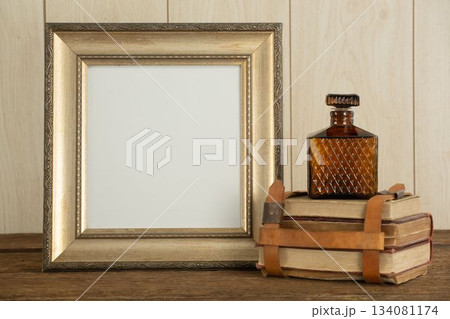 Photo frame, perfume and book stack on table Photo frame, perfume and book stack on table 134081174