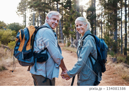 Love, hiking and portrait of old couple holding hands on nature walk in mountain forest in Canada. Travel, senior man and woman on hike with smile on face and health on retirement holiday adventure. Love, hiking and portrait of old couple holding hands on nature walk in mountain forest in Canada. Travel, senior man and woman on hike with smile on face and health on retirement holiday adventure. 134081386