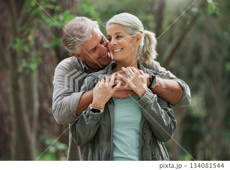 Hug, hiking and senior couple in nature with smile on adventure in forest, woods and mountain for exercise. Fitness, retirement and happy elderly man and woman on trekking hike for travel wellness Hug, hiking and senior couple in nature with smile on adventure in forest, woods and mountain for exercise. Fitness, retirement and happy elderly man and woman on trekking hike for travel wellness 134081544