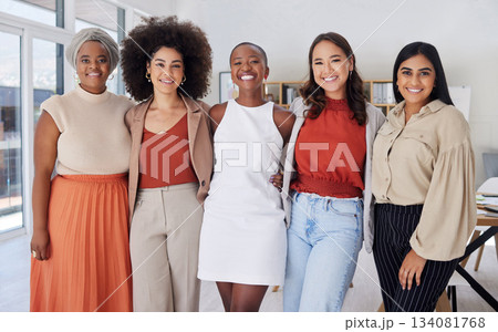 Portrait of a diverse group of smiling ethnic business women standing together in the office. Ambitious happy confident professional team of colleagues embracing while feeling supported and empowered 134081768