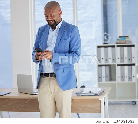 Happy black man, phone or text in business office for financial deal research, banking app or investment management. Smile, corporate or businessperson on mobile technology for reading finance report 134081983