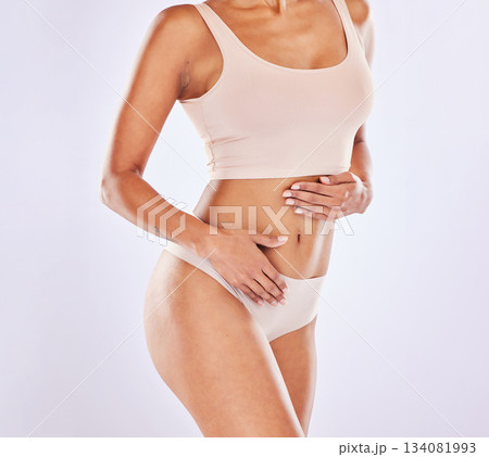 Body, weight loss and natural model in underwear with smooth skin isolated in a studio white background. Wellness, diet and female or woman touch stomach for healthcare, fitness and nutrition Body, weight loss and natural model in underwear with smooth skin isolated in a studio white background. Wellness, diet and female or woman touch stomach for healthcare, fitness and nutrition 134081993