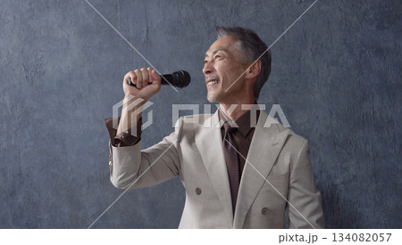 マイクで歌うシニアの男性 黒背景 マイクで歌うシニアの男性 黒背景 134082057