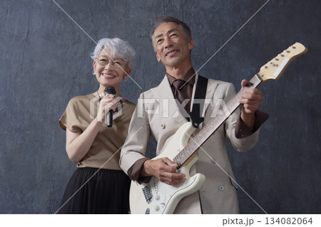 シニアのミュージシャン　男性のギタリストと女性のボーカル　黒背景 134082064