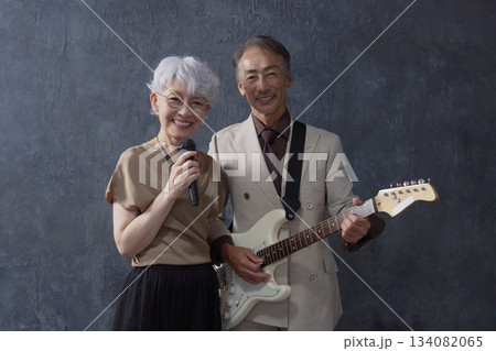 シニアのミュージシャン　男性のギタリストと女性のボーカル　黒背景 134082065