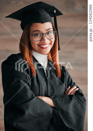 Graduation cap, proud portrait and woman isolated on wood background happy education, college or scholarship success. Biracial person, university student or graduate with learning knowledge mindset 134082066