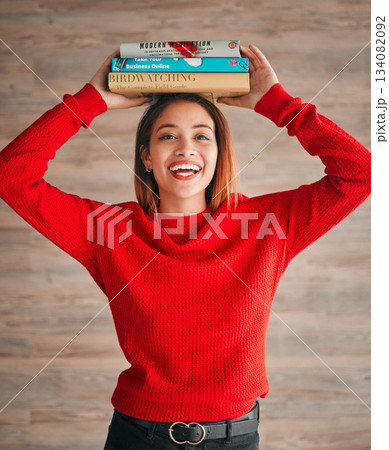 Reading, student and woman with books on her head while studying in college for a test or exam. Thinking, thoughtful and young female with stories, novels or fiction standing by a wall in the library Reading, student and woman with books on her head while studying in college for a test or exam. Thinking, thoughtful and young female with stories, novels or fiction standing by a wall in the library 134082092