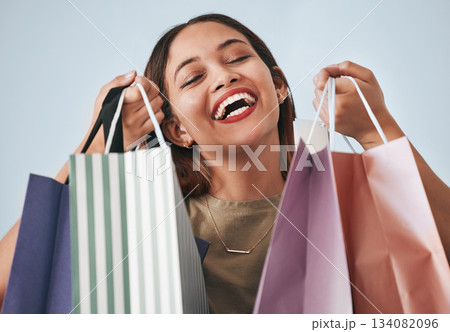 Shopping bag, portrait and happy woman isolated on studio background wealth, financial freedom or sales promotion. Retail, fashion and excited face of model, person or customer with paper bags offer Shopping bag, portrait and happy woman isolated on studio background wealth, financial freedom or sales promotion. Retail, fashion and excited face of model, person or customer with paper bags offer 134082096