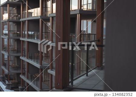 Flat design is showing multi story balcony facade with glass railings, tiled floor, snow on ground 134082352