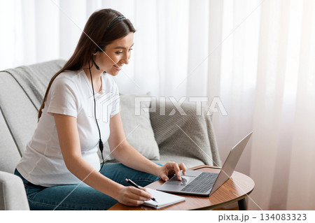 Distance Learning. Smiling Young Pregnant Woman In Headset Study With Laptop At Home, Happy Expectant Woman Watching Webinar In Internet And Taking Notes, Enjoying Online Education, Copy Space 134083323