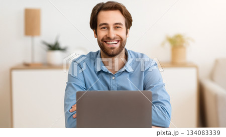 Successful Businessman's Portrait. Happy Entrepreneur At Laptop Computer Smiling To Camera Sitting At Workplace In Modern Office. Freelance Career, Distance Work And Entrepreneurship Concept 134083339