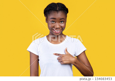 Cheerful Black Young Lady Pointing Finger At Herself Standing Posing Over Yellow Studio Background. Choose Me. Self-Confidence And Identity. It's Me Concept Cheerful Black Young Lady Pointing Finger At Herself Standing Posing Over Yellow Studio Background. Choose Me. Self-Confidence And Identity. It's Me Concept 134083453