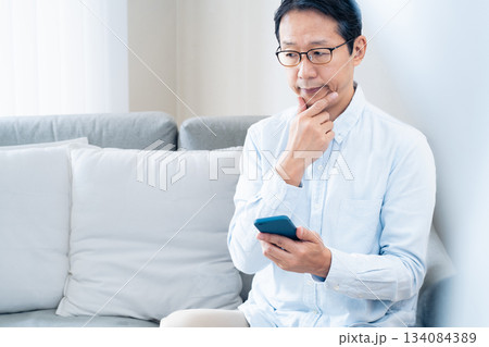 スマホを使う中高年男性 スマホを使う中高年男性 134084389