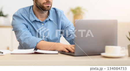 Focused Businessman Frowning Working On Laptop Having Difficult Task At Workplace In Modern Office. Serious Entrepreneur Typing On Computer Indoors, Having Issue With Internet Connection 134084733