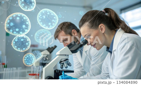 Focused male and female scientist team in laboratory conducting medical research on virus with microscope, showing happy concentration 134084890