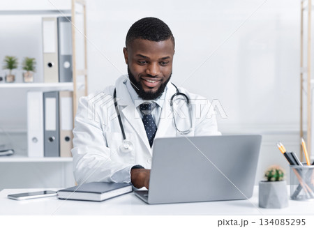 Highly qualified black doctor consultating patients online from his office during quarantine Highly qualified black doctor consultating patients online from his office during quarantine 134085295
