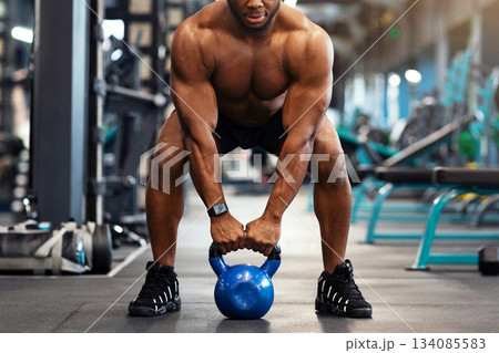 Muscular shirtless african american guy bodybuilder exercising with kettlebell at gym, looking at camera, copy space. Athletic black man making weightlifting or powerlifting, working on body musculs Muscular shirtless african american guy bodybuilder exercising with kettlebell at gym, looking at camera, copy space. Athletic black man making weightlifting or powerlifting, working on body musculs 134085583
