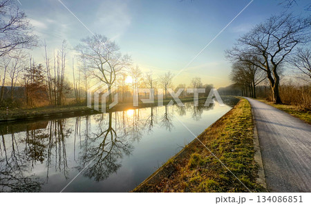 A Serene Sunrise by the Peaceful Canal Featuring Beautifully Reflective Trees Nearby and Beyond A Serene Sunrise by the Peaceful Canal Featuring Beautifully Reflective Trees Nearby and Beyond 134086851