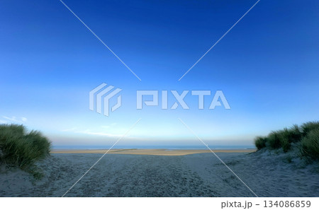 A serene beach landscape under a clear blue sky invites relaxation and peaceful moments A serene beach landscape under a clear blue sky invites relaxation and peaceful moments 134086859
