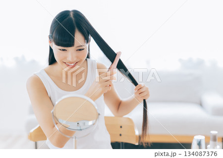 ヘアアイロンを使う若い女性 ヘアアイロンを使う若い女性 134087376