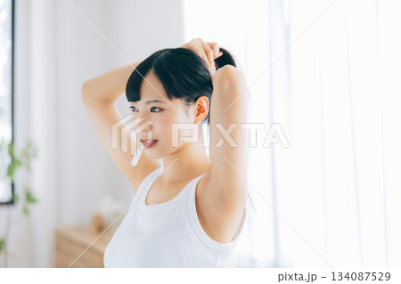 歯ブラシを咥えたまま髪の毛をまとめる若い女性 134087529