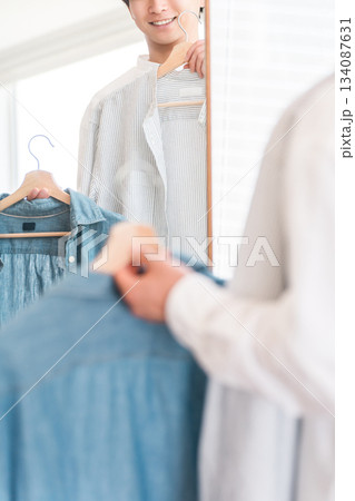 鏡を見ながら服をコーディネートする若いアジア人男性 鏡を見ながら服をコーディネートする若いアジア人男性 134087631
