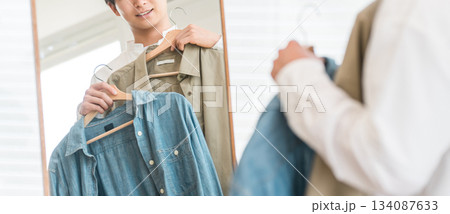 鏡を見ながら服をコーディネートする若いアジア人男性 134087633