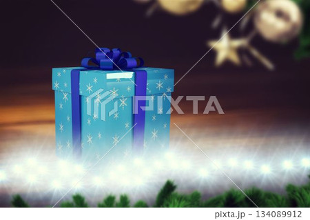Blue gift box is sitting on LED-lit platform, with dark blue ribbon, pine garland and baubles Blue gift box is sitting on LED-lit platform, with dark blue ribbon, pine garland and baubles 134089912