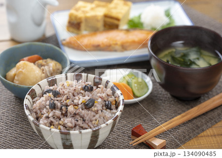 雑穀米と焼き鮭が並ぶ落ち着いた和風の朝食セット 134090485