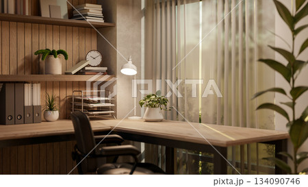 Wooden table with a lamp and armchair near a curtain covered glass window with nature view outside. Wooden table with a lamp and armchair near a curtain covered glass window with nature view outside. 134090746