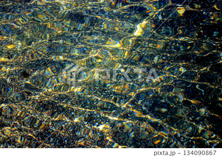金色と青黒基調色のカラフルで透明度の高いら螺鈿風海面波紋テクスチャー（レタッチ＆色彩加工画像） 134090867