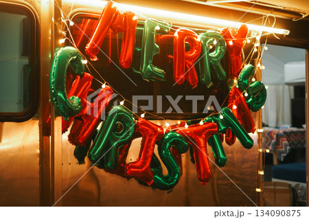 Festive Red and Green MERRY CHRISTMAS Balloons on a Trailer 134090875